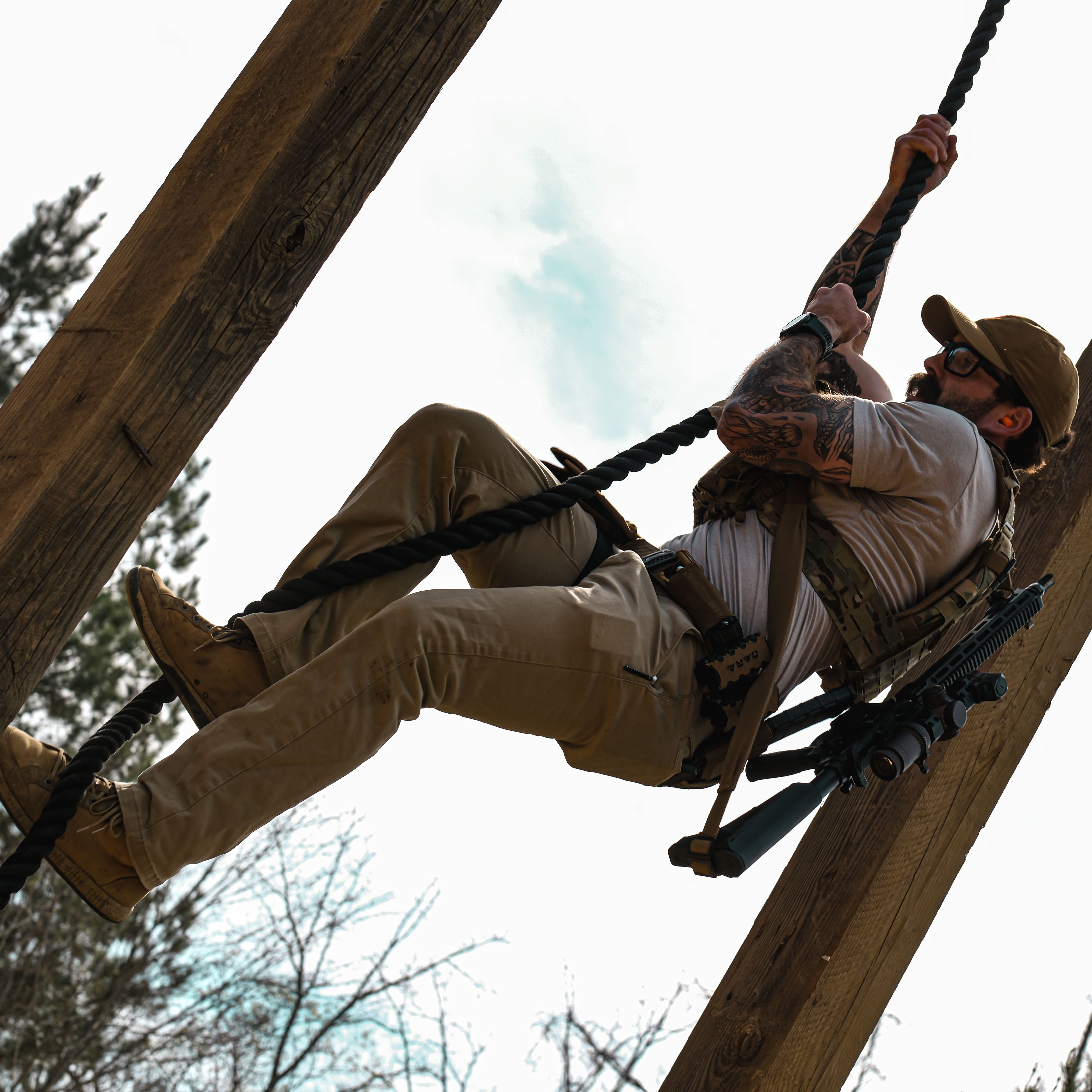 Jon Dara, of Dara Holsters, climbing a rope in kit during the Gauntlet Match